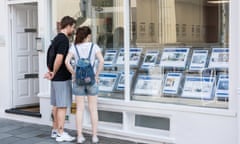 Young couple looking in estate agent's window