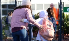 A mum says goodbye to her daughter outside a primary school.