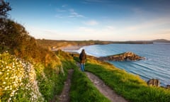 a walker on the Pembrokeshire Coast Path at Whitesands near St Davids, Wales.