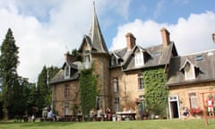 Widescreen shot of Chateau de la Baudonniere in Normandy, near Les Chambres, France. The image shows families eating outside the chateau, communally.