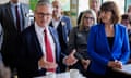 Keir Starmer, sitting next to Rachel Reeves, gestures while talking to people