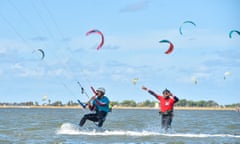 An instructor helps a kitesurfer perfect his water start on the Stagnone Lagoon, Sicily