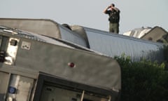 A law enforcement officer inspects the scene of an Amtrak train which derailed after striking a dump truck Monday, June 27, 2022, near Mendon, Mo. (AP Photo/Charlie Riedel)