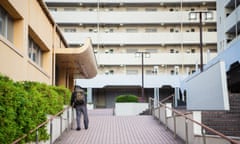 An elderly man walks home at the Atago public housing complex after getting off the bus.