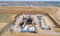 Landscape of boxes, cars and cranes in the middle of a field.