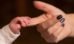 hand of baby holding adult finger