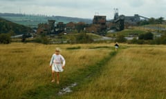 Girls walk on a country path near an open-air mine in Yorkshire along a muddy path