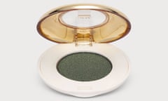 A round, open eye shadow case with green eye shadow