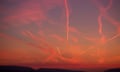 Contrails, vapour trails from planes across the sky, during sunrise