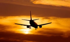 Airplane landing at Manchester Airport at sunset