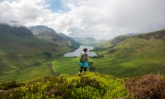 A woman looks out over Buttermere from the Fleetwith Pike in in The Lake District.<br>Buttermere, Cumbria, The Lake District, England.