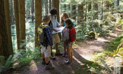 Adult and children Map reading in the woods