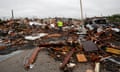 Man in neon jacket stands in wreckage