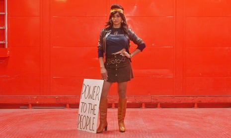 Koriangelis Brawns standing against a red backdrop with a sign saying 'power to the people'.