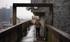 A woman walks along an elevated walkway on the Falinge Estate, which has been surveyed as the most deprived area in England for a fifth year in a row