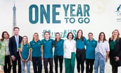 Politicians Anika Wells, Chris Minns, Annastacia Palaszczuk pose with past and present Australian athletes in front of a 'one year to go' sign