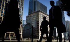 Silhouetted people walking in Canary Wharf at rush hour