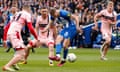 Brighton's Evan Ferguson, who has found space between two opponents, scores his side's second goal against Grimsby in the FA Cup quarter-final with a right-footed shot.