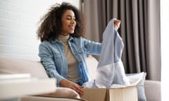 Young woman opening package of fashion item bought online