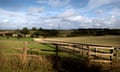 Green fields and fences under a blue sky