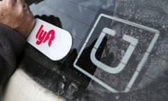 Uber and Lyft stickers can be seen attached to the back windshield of a car