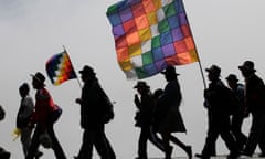 Protesters carry flags representing their indigenous movement in Bolivia.