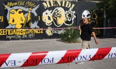 A man walks at the spot where a man was fatally stabbed during clashes between football supporters outside the AEK football club stadium in Athens, Greece.