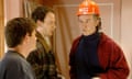 Alan Partridge wearing hard hat with 'boss' on it tries to bond over sport with his builders.