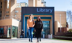 Students walking about of the campus library building at Coventry University.