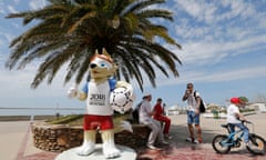 Russian tourists take a rest during their walk along a coastline, next to a mascot of the World Cup 2018, in Sochi, Russia, 19 May 2018.