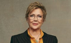Annette Bening in a black pinstripe suit and a mustard blouse