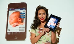 Myleene Klass holds a tablet running the Mothercare app