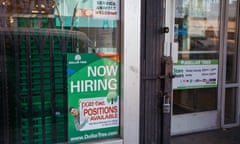 A now hiring sign in a shop window