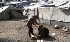 A Syrian woman cooks outside her tent at Ritsona refugee camp in Greece.