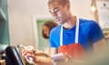 coffee shop worker with digital order screen<br>a young coffee shop worker entering the order into the a digital display screen