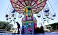 A worker cleans a colorful amusement park ride