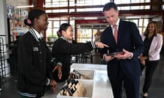 New South Wales Premier Chris Minns learns how to check a phone in during a visit to Condell Park High School