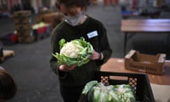 A volunteer works to sort food and create food parcels for those in need