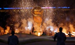 World Cup workers wave a giant flag at the Qatar 2022 closing ceremony, held before the final at Lusail Stadium.