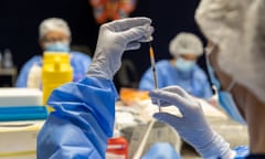 A healthcare worker fills a syringe with Pfizer vaccine