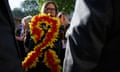 A woman holds a bouquet of flowers in the campaign colours as families affected by the infected blood scandal hear the findings of the six-year inquiry.