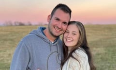 A smiling young couple embrace each other.