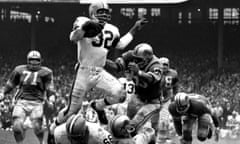 Jim Brown, No 32 of the Cleveland Browns, runs through the defence during a 1964 game against the Detroit Lions at Cleveland Municipal Stadium.