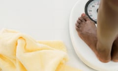 View of feet of a woman standing on weighing scale