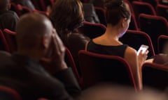 Rear view of woman using phone in theatRE audience