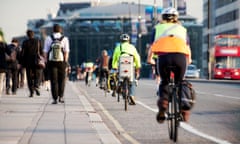 Commuters on foot and cycling<br>City workers walking and cycling over Waterloo Bridge at the end of the working day. Crash zoom effect done in camera.