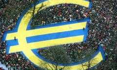 Thousands stand around a euro symbol in Frankfurt's banking district on 1 January 1999.