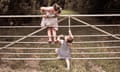 Two children playing on a fence