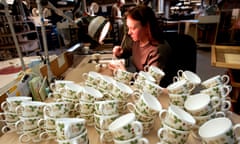 A worker at the former Wedgewood factory and pottery in Stoke-on-Trent paints a design on teacups.