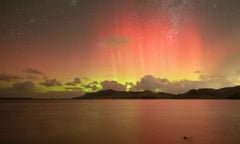 Red, orange and yellow night sky from the aurora australis (southern lights) over water